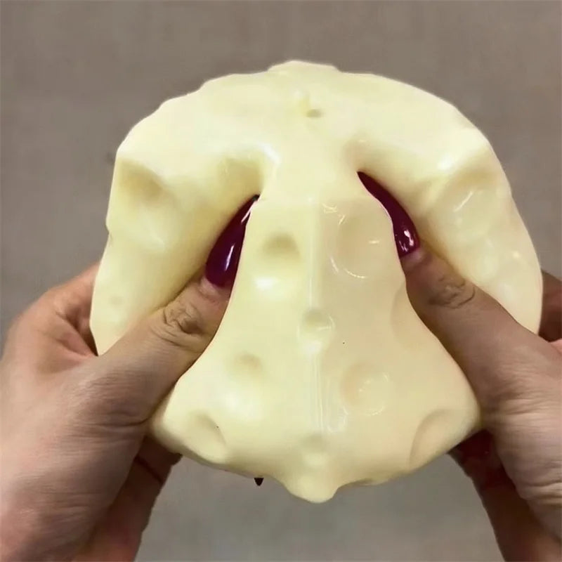 Cheese-shaped squishy stress ball shown from the side on a neutral backdrop.